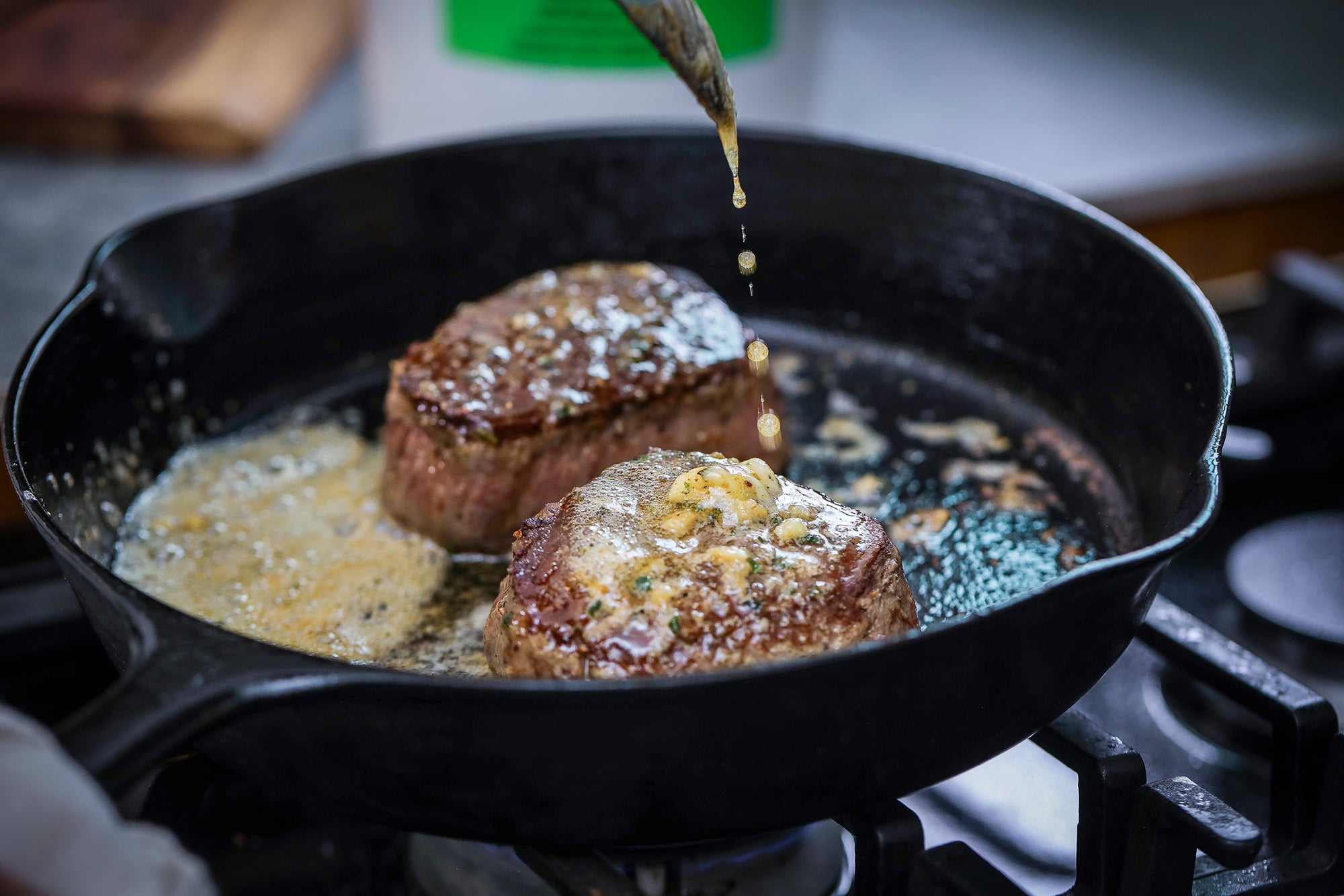 Steak cooking in cast iron with Epicurean Butter Roasted Garlic Herb Flavored Butter